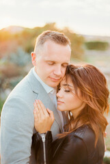 Bride and groom embrace with their eyes closed. Portrait