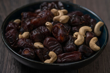 Raw kashew nuts and figs served in black bowl