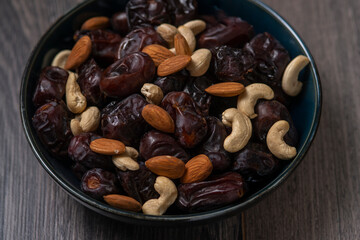 Fototapeta na wymiar Raw cashew nuts and figs served in black bowl
