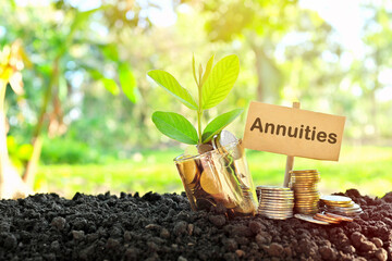 Investment on annuities concept. Coins in a jar with soil and growing plant in nature background. - obrazy, fototapety, plakaty