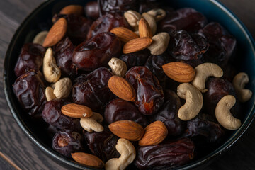 Raw cashew nuts and figs served in black bowl