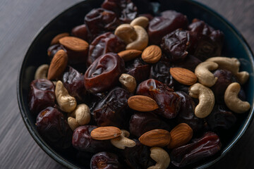 Raw cashew nuts and figs served in black bowl