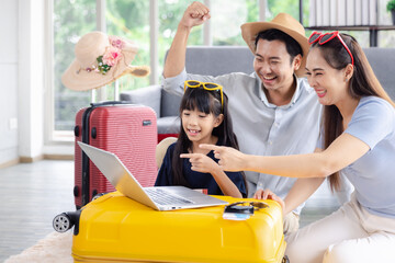 Young happy family asian father mother and daughter happy exciting preparing luggage suitcase booking ticket and hotel for vacation holiday travel trip