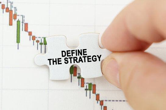 Against the background of the quotes chart, a puzzle with the inscription - Define The Strategy