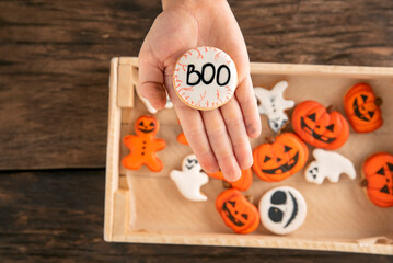 Halloween gingerbread. Cookies in the form of ghost and pumpkins. Cookies with Boo on the palm.