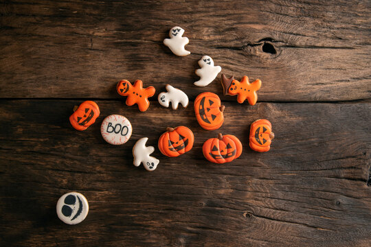 Halloween gingerbread cookies on wooden planks. Halloween pumpkin, ghosts and gingerman. Top view.