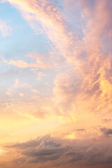 Sky texture with beautiful clouds, light from the sun at dawn, vertical view