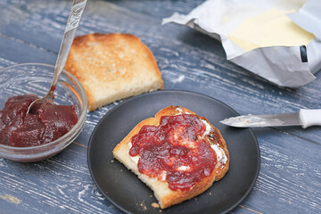 traditional breakfast with toasts, butter and berry jam or marmalade. rustic table and morning meal