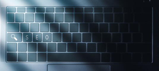 Laptop keyboard with blue light and SEO text on buttons. SEO Search Engine Optimization concept....