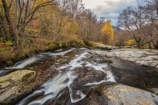 Stunning vibrant landscape image of Aira Force Upper Falls in Lake District during colorful Autumn showing