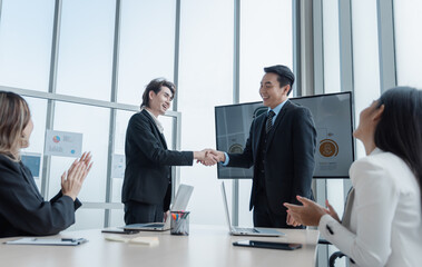 Business group in meeting having hand shake for business deal agreement or celebrating success in boardroom modern office
