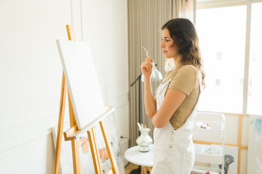 Inspired woman artist thinking about a new painting