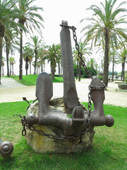 TARRAGONA, SPAIN - 06.07.2022: Iron black old rusty naval anchor monument in parc