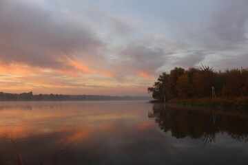 Naklejka na ściany i meble Piękny jesienny wschód słońca nad rzeką we mgle.