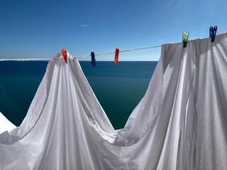 clothes drying on the rope with pins at sea horizon background
