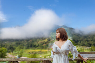photo of woman life up a cup of coffee,and view of foggy cover over mountain,travel concept