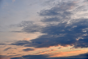 Obraz premium Sunset sky with pink and blue clouds in summer. Beautiful sunset with the sun.