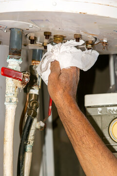 Solar boiler electrician. Solar water heater installer. Drains the boiler from the leak. with paper
