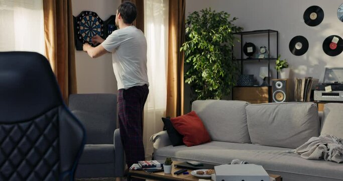 Brunet plays darts in his spare time to practice his target throwing skills. The man is happy with the gift he received. Entertainment at home.