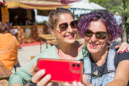 Friends taking a selfie outdoors. Two smiling women taking a photo. Concept of friendship. Lifestyle. 