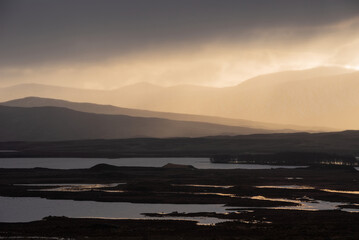 Epic Winter landscape image of view along Rannoch Moor during heavy rainfall giving misty look to the scene