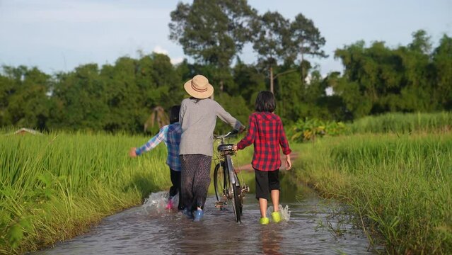 Mother and daughter are asian family walking and looking flooding in rural