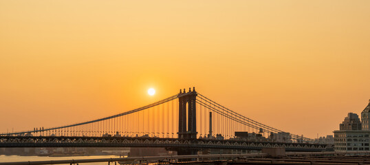 Manhattan Bridge at sunrise and some disc of the rising sun
