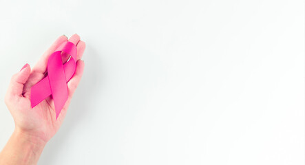 Cancer awareness. Health care symbol pink ribbon in woman hands on white background. Breast woman support concept. World cancer day.