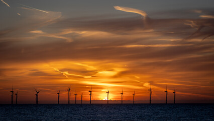 Fototapeta premium Off-shore wind farm in the North Sea at sunrise.