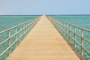 Obraz premium Very long wooden pier footbridge in ocean sea. High quality photo