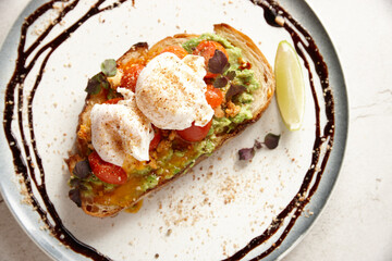 avocado toast with tomatoes and white cheese on top