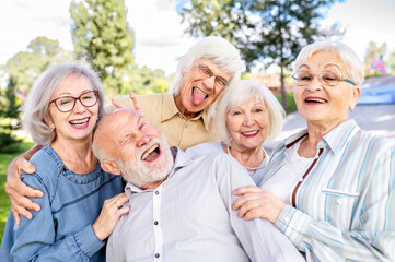 Group of senior friends bonding at the park - Elderly old people meeting and having fun outdoors