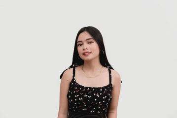 An Asian young woman poses for the camera for a studio shot isolated on a white background.