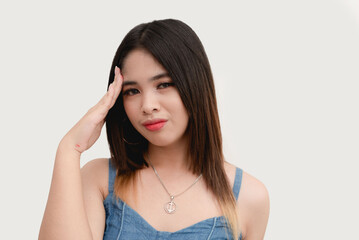 An Asian female massages the temple part of her head as she experiences headache. Studio shot isolated on white background.