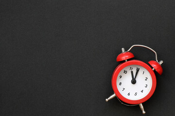 Red alarm clock on a black background