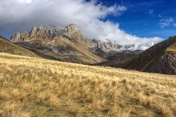 vue large du col des Rochilles avec des nuages au sommet