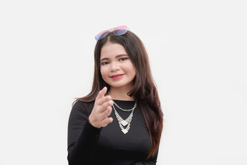 A young Asian woman extends her hand to initiate a firm handshake. Posing for a studio shot isolated on a white background.