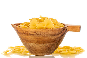 Several raw butterfly macaroni in a wooden cup, macro, isolated on white background.