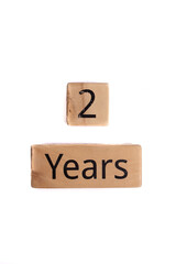 Wooden cubes with the inscription 2 years. On a white background.