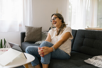 Adult woman having video call at home using tablet