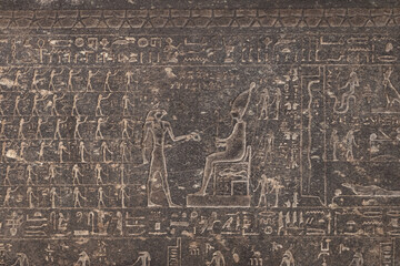 Old engraved drawing on the dark grey tomb wall.