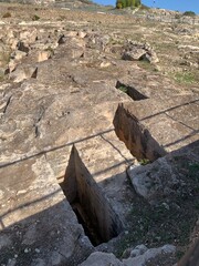 Archaeological area at a large hillside necropolis featuring Carthaginian and Roman burial chambers.