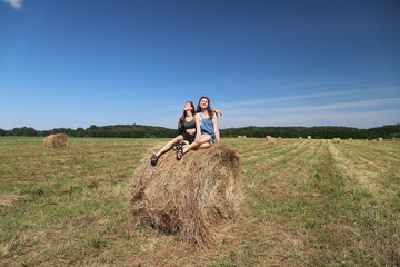 group of friends in a field with a haystack