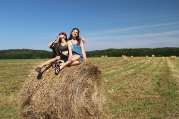 Naklejka na ściany i meble group of friends in a field with a haystack