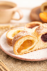 Homemade sweet bun with apricot jam on white wooden. side view, selective focus.