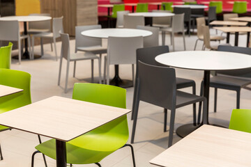 Empty tables and comfortable seating at a food court in a shopping mall.