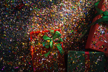 Background of colorful glitter over the present box that put on the floor. Gift box for Christmas Eve and Happy new year.