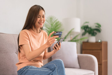 Concept of activity in home, Young woman using phone and credit card to payment for shopping online