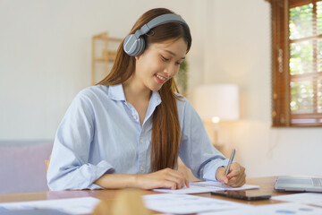 Remote business concept, Businesswoman wear headphone to meeting in video call and taking notes