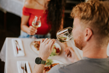 Young couple having lunch with white wine in the restaurant